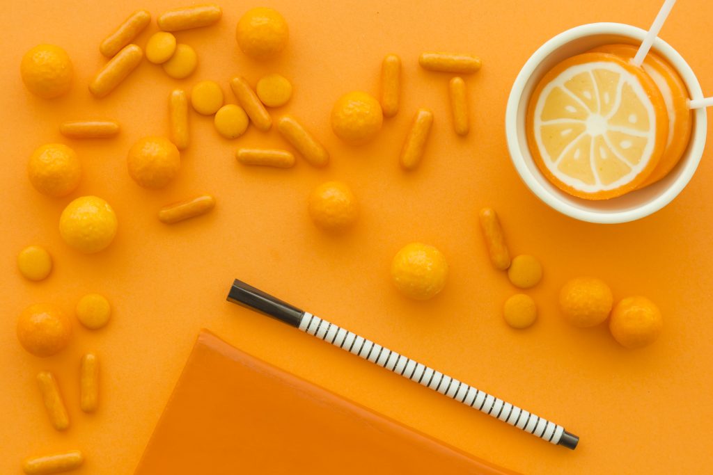 elevated view pen lollipops with scattered candies orange surface